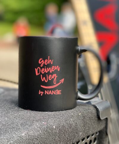 Becher "Geh Deinen Weg!" von NANÉE, Schwarzer Keramikbecher, Innen rot, mit hochwertiger roter Lasergravur "Geh Deinen Weg" by NANÉE